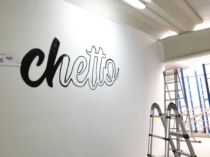 Rotulación de logotipo en negro pintado sobre pared