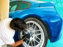 Artista pintando la rueda de un BMW