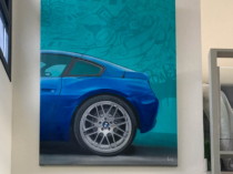 Pintura realista de un BMW azul con fondo graffiti
