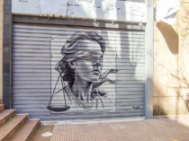 graffiti de rostro mujer sobre persiana metalica