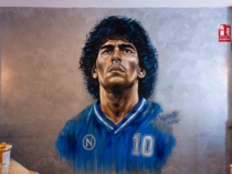 Retrato mural de Maradona con la camiseta azul del Nápo