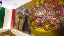 Luchador con iconografía azteca en mural mexicano pintado a mano