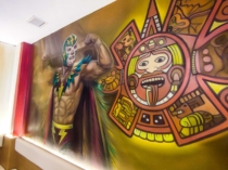 Luchador con iconografía azteca en mural mexicano pintado a mano
