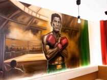 Pintura mural mexicana en interior de restaurante con figura de boxeador