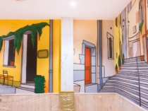 Mural de fachadas y callejones pintado sobre pared de restaurante