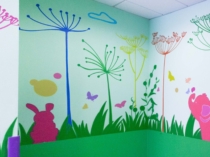 Mural de animalitos pintado en la pared de una escuela infantil