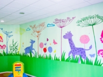 Mural infantil de jirafas, flores y plantas en una guardería
