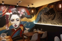 Una geisha pintada en la pared de un restaurante