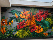 Mural de flores en pared exterior pintado a mano con vegetación tropical. Un diseño personalizado para dar color a patios, jardines y fachadas.